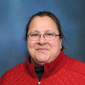 Portrait of Leslie Bachar in a red sweater.
