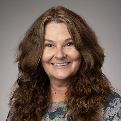 Portrait of Pamelia Bertrand in a green printed dress shirt.