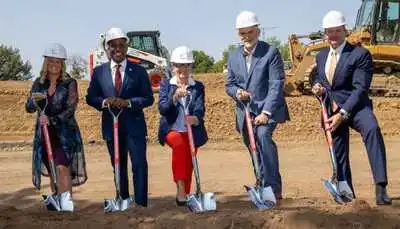 Five people with hard hats and shovels at groundbreaking ceremony