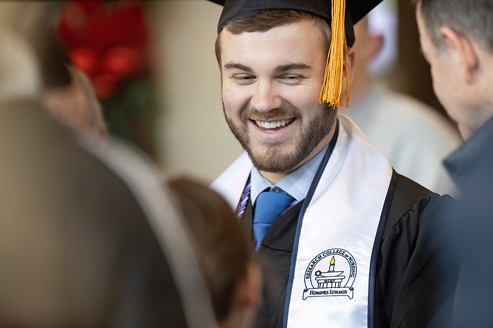 Portrait of a happy student at graduation in his cap and gown.