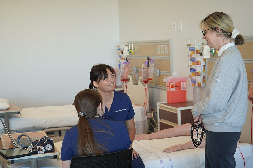 Professor talking to students in a simulation lab.