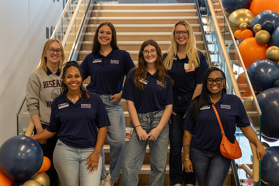 Portrait of students standing by the stairs at the dedication event.