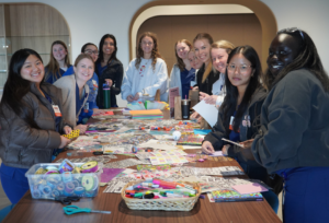 Students gathered around a long table crafting journals.